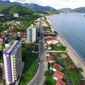 an aerial view of a city and the beach at Casa de Praia Massaguaçu! Ao meio Áreas Arborizadas in Caraguatatuba