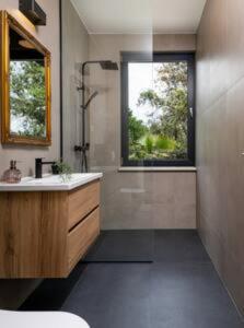 a bathroom with a sink and a shower and a window at Luxury Holiday House Skrip with Private Pool in Škrip