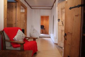 阿爾代茲的住宿－Chasa Campell，一间带椅子和红色毯子的客厅
