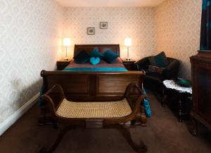 a bedroom with a bed with a chair and a couch at Glenart House in Tramore