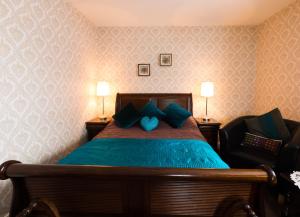 Schlafzimmer mit einem Bett mit blauer Bettwäsche und Kissen in der Unterkunft Glenart House in Tramore
