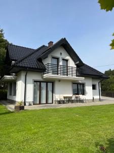 uma casa branca com uma mesa e cadeiras num quintal em Dom w Zawadzie Lanckorońskiej 101 em Zakliczyn