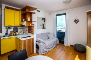 a small kitchen with yellow cabinets and a window at SE065 - Senigallia, meraviglioso bilocale sul mare in Senigallia