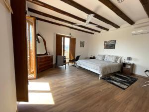 1 dormitorio con 1 cama y suelo de madera en Cal Campana, en Gratallops