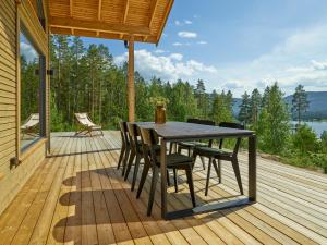 a wooden deck with a table and chairs on it at Furuheim Lodge, 4 seizoenen vakantiehuis met fantastisch uitzicht in Vradal