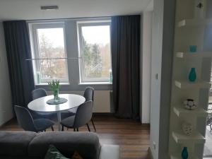 a living room with a table and chairs and a window at Apartament 35 in Olsztynek +1 photo