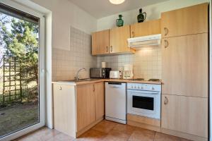 a small kitchen with white appliances and a window at Hof Verchen Nahe Kummerower See in Verchen +17 photos