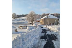 a road covered in snow next to a building at Gite Le Turquoise in Saint-Cirgues-en-Montagne