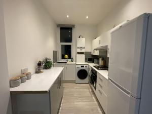 a kitchen with white counters and a white refrigerator at Modern Sea View Apartment in Margate