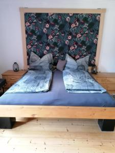 1 dormitorio con 1 cama grande y cabecero de flores en Ferienwohnung "Josefine und Ihr Kavalier", en Kundl