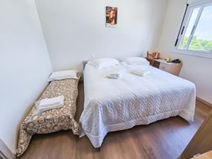 a small bedroom with a bed and a window at Pousada Bom Pastor in Caxias do Sul