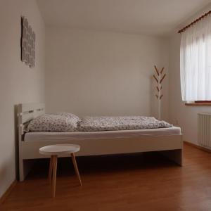 een slaapkamer met een bed en een kruk erin bij Nad Sklepy in Bořetice