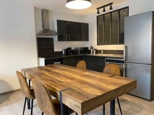 a kitchen with a wooden table and a refrigerator at Hypercentre * Calme * Cosy - Le Citadin in Pontarlier