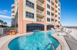 a swimming pool in front of a building at Harbour Place Unit 106 in Orange Beach