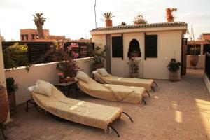 eine Terrasse mit Sofas und Betten auf einem Gebäude in der Unterkunft Riad Diana in Marrakesch