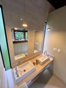 baño con 2 lavabos y espejo grande en Hospedaria Vila Serra da Luz, en Pindamonhangaba
