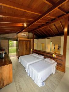 Habitación grande con 2 camas y techos de madera. en Hospedaria Vila Serra da Luz en Pindamonhangaba