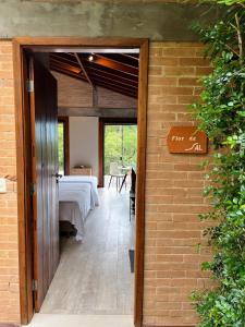 una puerta abierta a una habitación con una mesa en Hospedaria Vila Serra da Luz en Pindamonhangaba