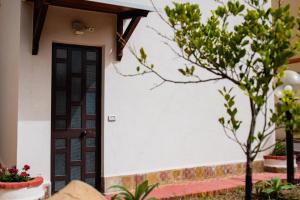 a house with a door and a tree at VILLA HEMINGWAY - LA CASA DI LEONARDO in Ficarazzi