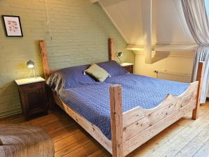 a bedroom with a wooden bed with a blue comforter at Studio midden in de natuur GR03 Grijpskerke in Grijpskerke