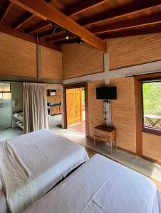 1 dormitorio con 1 cama y TV de pantalla plana en Hospedaria Vila Serra da Luz, en Pindamonhangaba