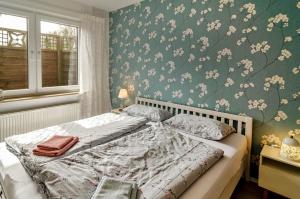 Schlafzimmer mit einem Bett mit Blumentapete in der Unterkunft Ferien Bei Familie Martin in Bad Zwischenahn