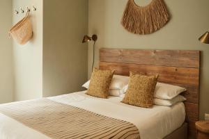 a bedroom with a bed with a wooden headboard and pillows at Primrose House St. Ives in St Ives