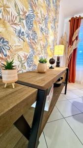 einem Holztisch mit Topfpflanzen an der Wand in der Unterkunft Le corail - Centre - Gayant - Gare in Douai