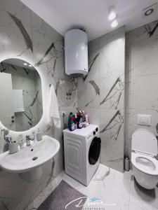 a bathroom with a sink and a toilet and a mirror at Dune Apartments, San Pietro Resort in Lalëz