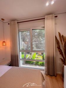 a bedroom with a large window with curtains at Dune Apartments, San Pietro Resort in Lalëz