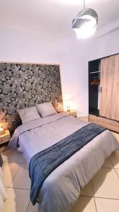 ein Schlafzimmer mit einem großen Bett mit einer Wand in der Unterkunft Le corail - Centre - Gayant - Gare in Douai