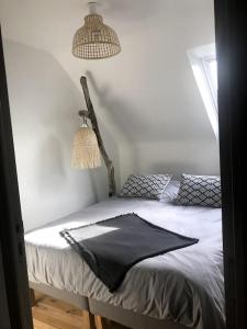 ein Schlafzimmer mit einem Bett mit einer schwarzen Decke darauf in der Unterkunft Petite maison bretonne P'ty Penty in Plougastel-Daoulas