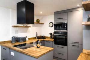 a kitchen with stainless steel appliances and a wooden counter top at Promenade View - seafront hideaway in Eastbourne