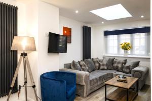 a living room with a couch and a tv at Promenade View - seafront hideaway in Eastbourne