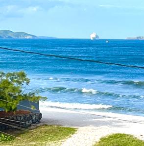 a view of the ocean with a ship in the distance at Central Praias III in Cabo Frio