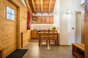 - une cuisine avec des placards en bois, une table et des chaises dans l'établissement Chalet Camping Faè 1, à Madonna di Campiglio
