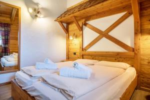 sypialnia z łóżkiem z ręcznikami w obiekcie Chalet Camping Faè 1 w Madonna di Campiglio