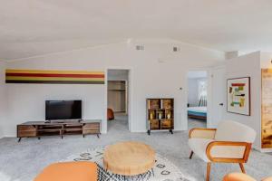 een woonkamer met een flatscreen-tv en oranje stoelen bij Groovy Getaway Centrally Located in Augusta