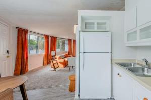 uma cozinha com um frigorífico branco e uma sala de estar em Groovy Getaway Centrally Located em Augusta