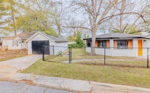 een huis met een hek voor een huis bij Groovy Getaway Centrally Located in Augusta