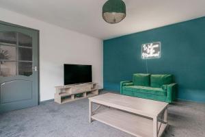 a living room with a green couch and a television at Cumbernauld Haven Hideout Sleeps upto 7 in Cumbernauld