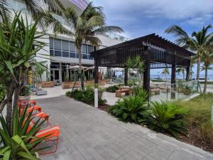 een gebouw met een patio met stoelen en palmbomen bij WVR Vacation Residences 602 in Fort Lauderdale