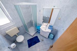 uma casa de banho com um WC, um lavatório e um chuveiro em Apartman Rab Blue em Rab
