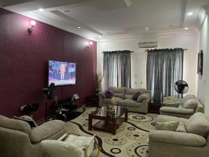 sala de estar con sofás y TV de pantalla plana. en Sparkle's Place, en Lagos