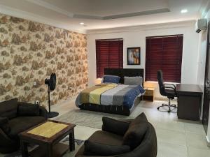1 dormitorio con cama y escritorio en Sparkle's Place, en Lagos