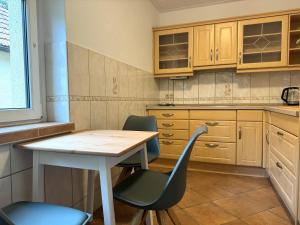 uma cozinha com mesa, cadeiras e armários em Ferienhaus "Jasmine" Hettstedt em Hettstedt