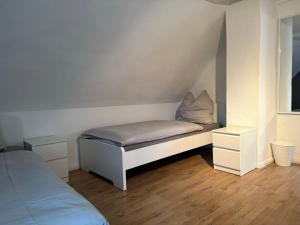 - une petite chambre avec un lit et 2 tables de chevet dans l'établissement Ferienhaus "Jasmine" Hettstedt, à Hettstedt