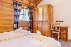 two beds in a room with a desk and a chair at Chalet Camping Faè 3 in Madonna di Campiglio