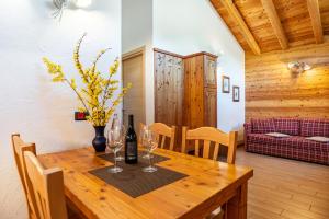 a dining room with a wooden table with wine glasses at Chalet Camping Faè 3 in Madonna di Campiglio