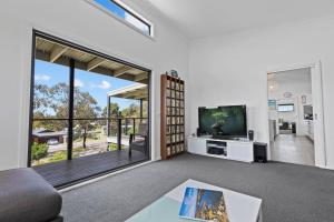 a living room with a tv and a large window at Elevation in Paynesville